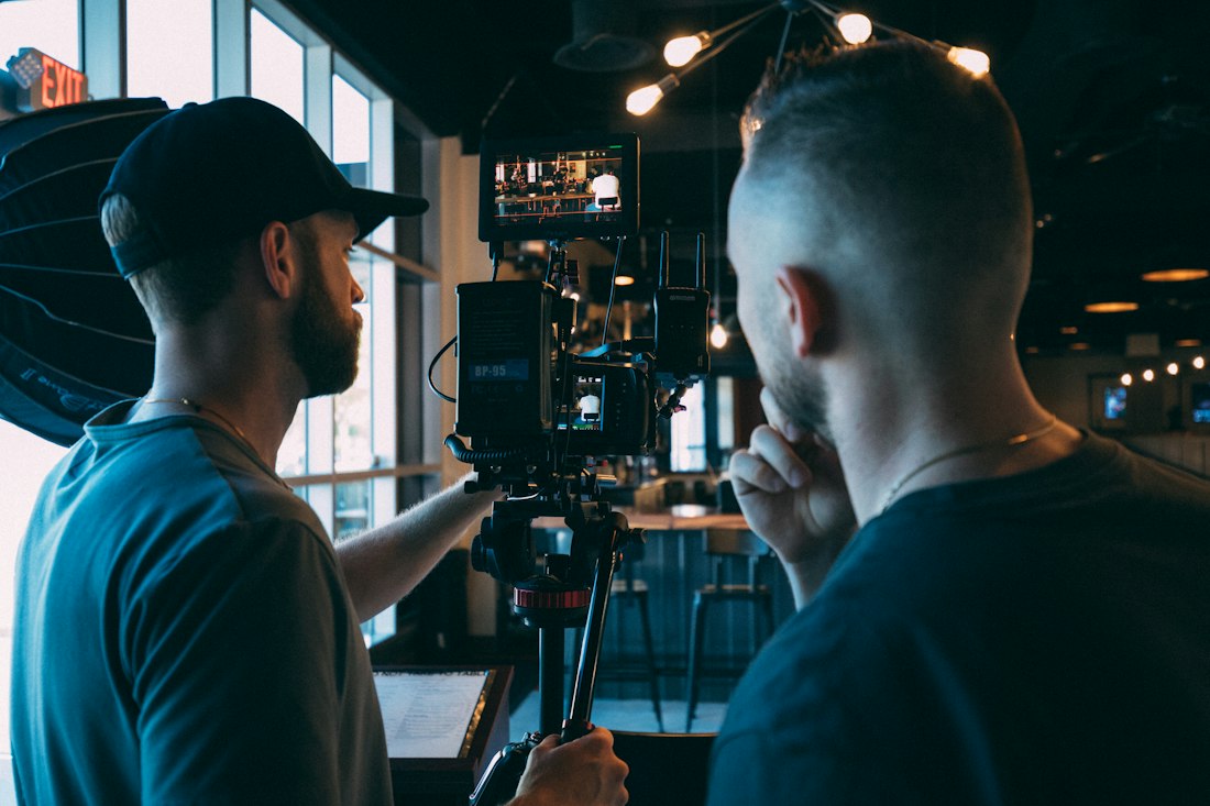 Two people recording a video with a camera and studio lighting